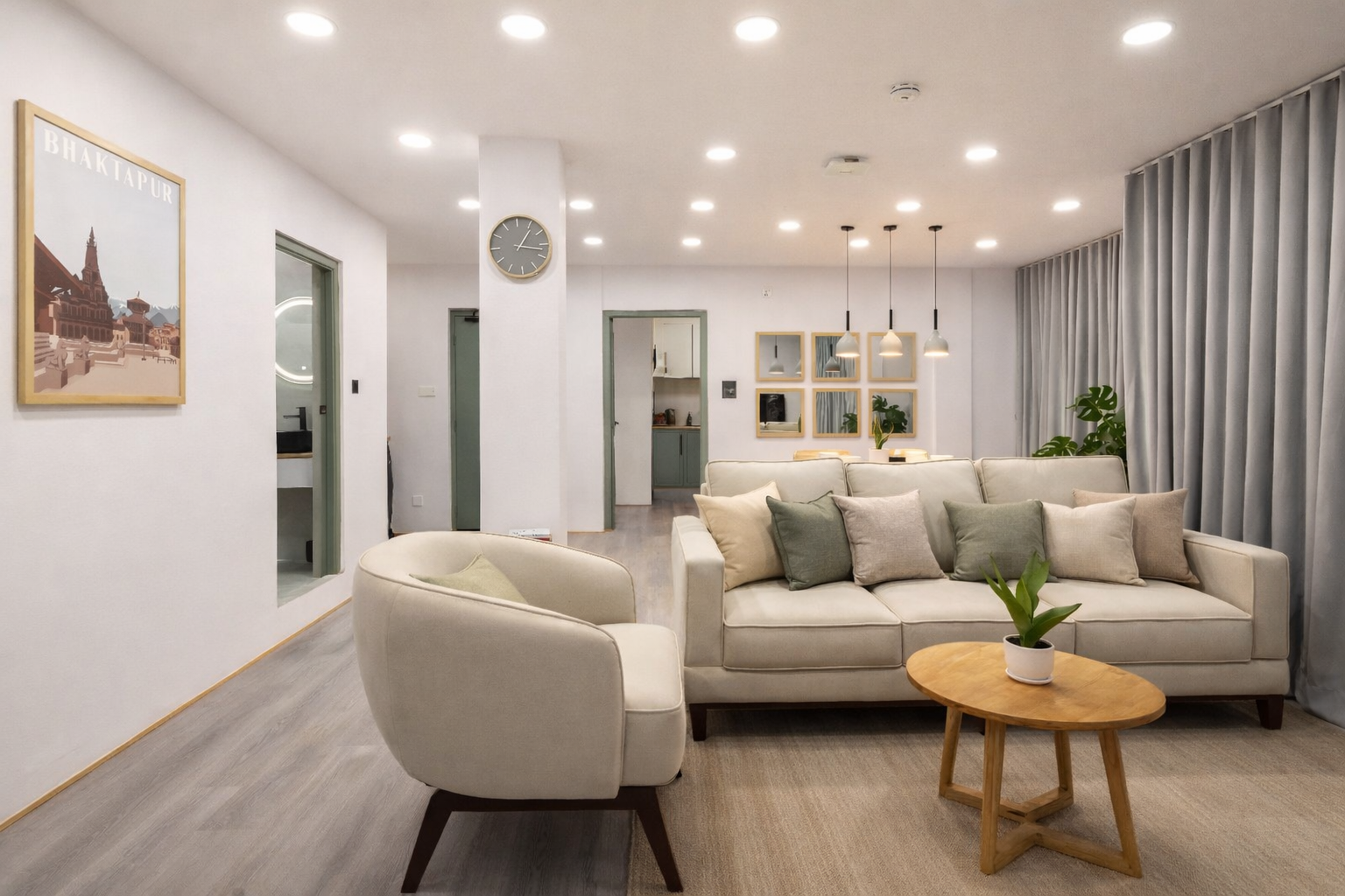 Tiny Living Apartments living room — Scandinavian-style sofa, framed Bhaktapur travel poster, pendant lights, planted styling and natural light